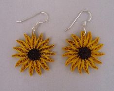 pair of yellow and black sunflower earrings on white background