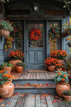 an entry way with potted plants and flowers on the front steps in fall colors