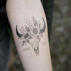 a cow skull with flowers on it's head and the words born in black ink