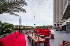 an outdoor seating area with red couches and tables