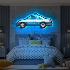 a police car is shown on the wall next to a bed with blue sheets and pillows