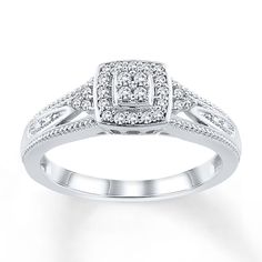 a white gold ring with diamonds on the sides and an intricate design in the center