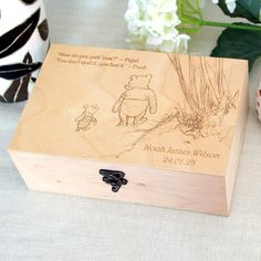 a winnie the pooh wooden music box next to some flowers