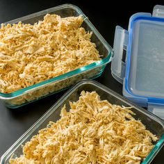 two glass dishes filled with food sitting on top of a table next to plastic containers