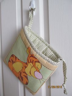 a winnie the pooh pot holder hanging on a door