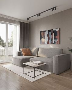 a living room with a couch, coffee table and large windows