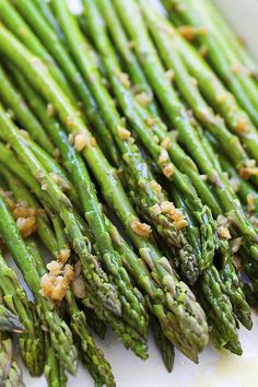 asparagus with garlic and parmesan on a white plate, ready to be eaten