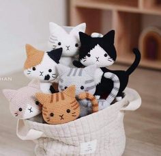 crocheted cat figurines sitting in a basket