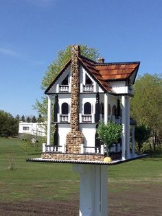 a white house sitting on top of a wooden pole