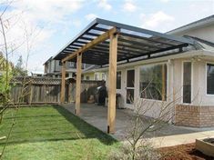 an outdoor patio with a pergolated roof and wooden posts on the side of it