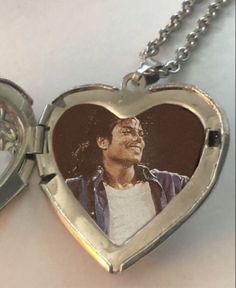 an open heart shaped locke with a photo on the front and inside, attached to a chain