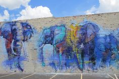 an elephant mural painted on the side of a building in front of a parking lot