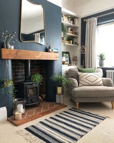 a living room filled with furniture and a fire place in front of a mirror on the wall