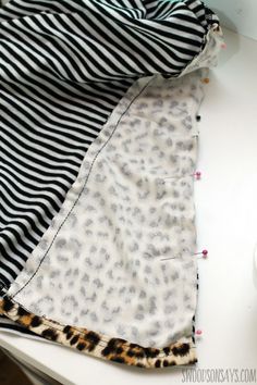 the sewing project is being made with black and white material, including a striped shirt