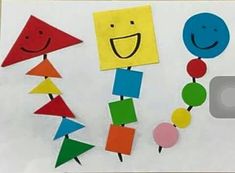 colorful paper cutouts with smiling faces and shapes on them are displayed in front of a white background