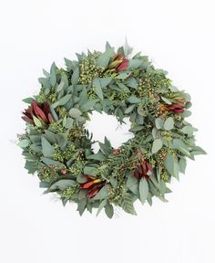 a green wreath with red berries and greenery