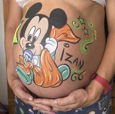 a pregnant woman's belly with mickey mouse painted on it and the words i love you