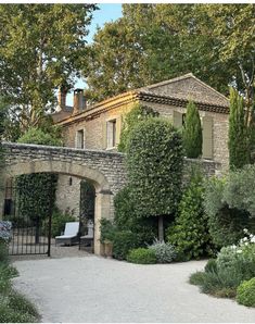 an old stone house surrounded by trees and bushes