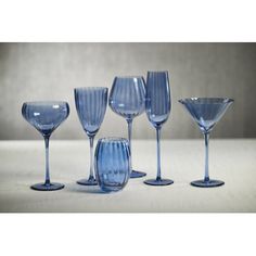 six blue wine glasses lined up on a table