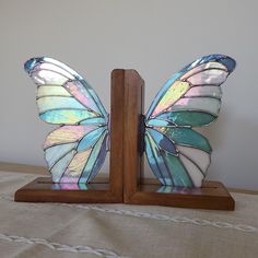 a glass butterfly sitting on top of a wooden stand