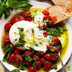 a white plate topped with tomatoes and bread