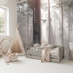 a child's room with a teepee tent and wall mural