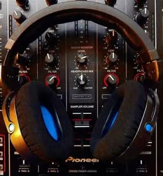 two headphones sitting on top of a dj's control panel in front of sound mixers