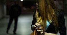 a woman with long blonde hair is holding a brown bag and looking at another person