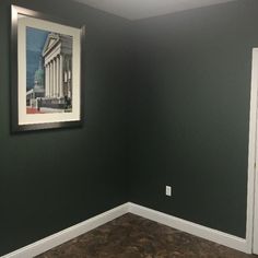 an empty room with a painting hanging on the wall and a door to another room