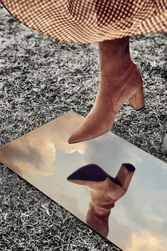 a woman's feet in high heeled shoes standing on top of a rug