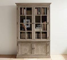 an old bookcase with many books in it on the floor next to a window