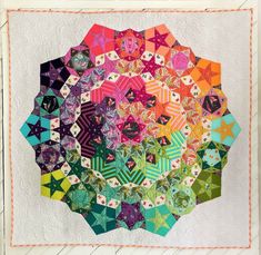 a quilted wall hanging with many different colors and designs on it's sides