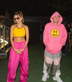 two people in matching outfits standing next to each other