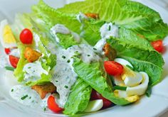 a salad with dressing and vegetables on a white plate