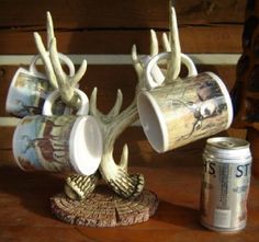 two cups with antlers on them are next to a can