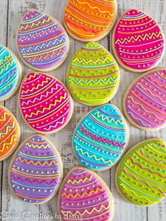 decorated easter cookies on a white wooden table with colorful eggs in the background and text overlay