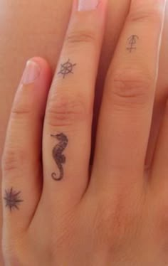 a woman's hand with two small tattoos on it