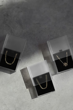 three boxes with necklaces in them sitting on the ground