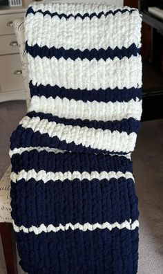 a crocheted chair cushion sitting on top of a wooden table next to a white dresser