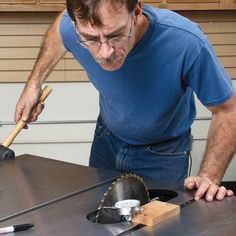 a man is using a circular saw to cut wood