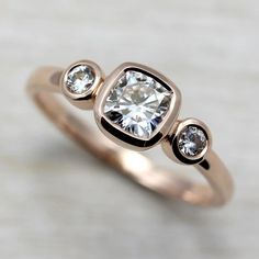 a gold ring with three diamonds on it