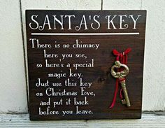 a wooden sign that says santa's key and has a red ribbon on it