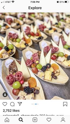 the app is showing different types of cheeses and fruits on wooden trays, along with other appetizers