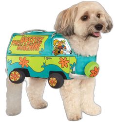 a white dog wearing a blue and green van costume with cartoon characters on it's side