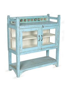 an old blue cabinet with glass doors and drawers on the bottom shelf is shown against a white background