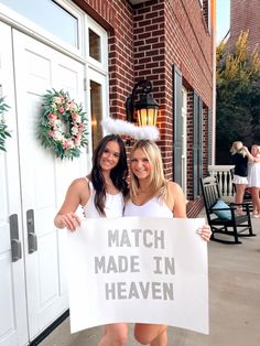 two women holding a sign that says match made in heaven