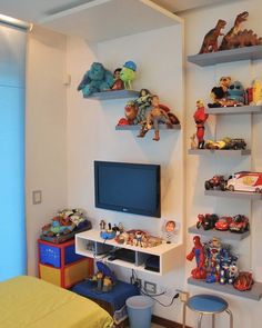 there is a tv and shelves in the room with toy animals on top of it