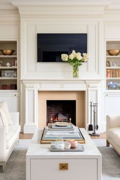 a living room filled with furniture and a fire place in front of a tv mounted above a fireplace