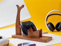 a wooden stand with two video game controllers on it and headphones in the background