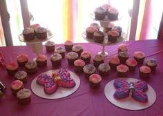 cupcakes and cookies are arranged on the table